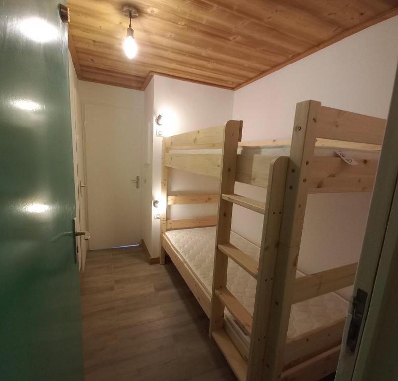 Cette chambre comprend 2 lits superposés et une porte. dans l'établissement Cocon familial au pied des pistes, à Morillon