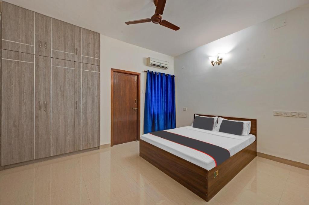 a bedroom with a bed and a ceiling fan at Chennai Airport Guest House in Chennai