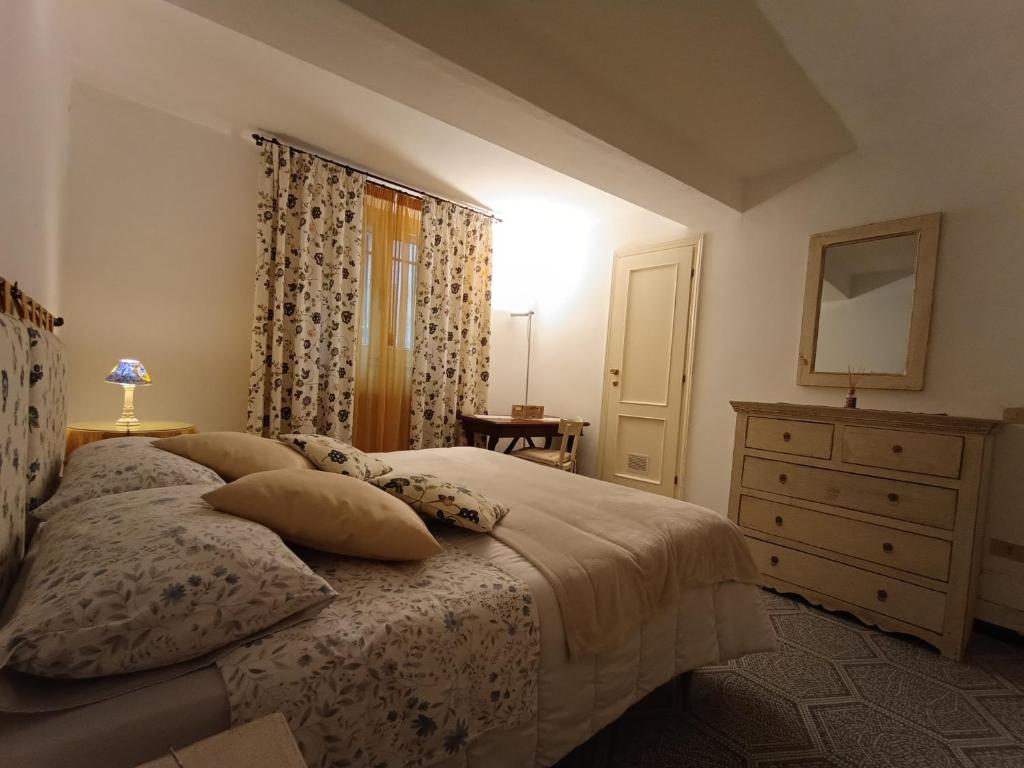 una camera da letto con un letto con un comò e uno specchio di Appartamento in Santa Caterina a Siena