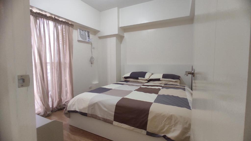 Affordable staycation BRAND NEW 2BR (39B) Infina Towers Aurora Boulevard tesisinde bir odada yatak veya yataklar
