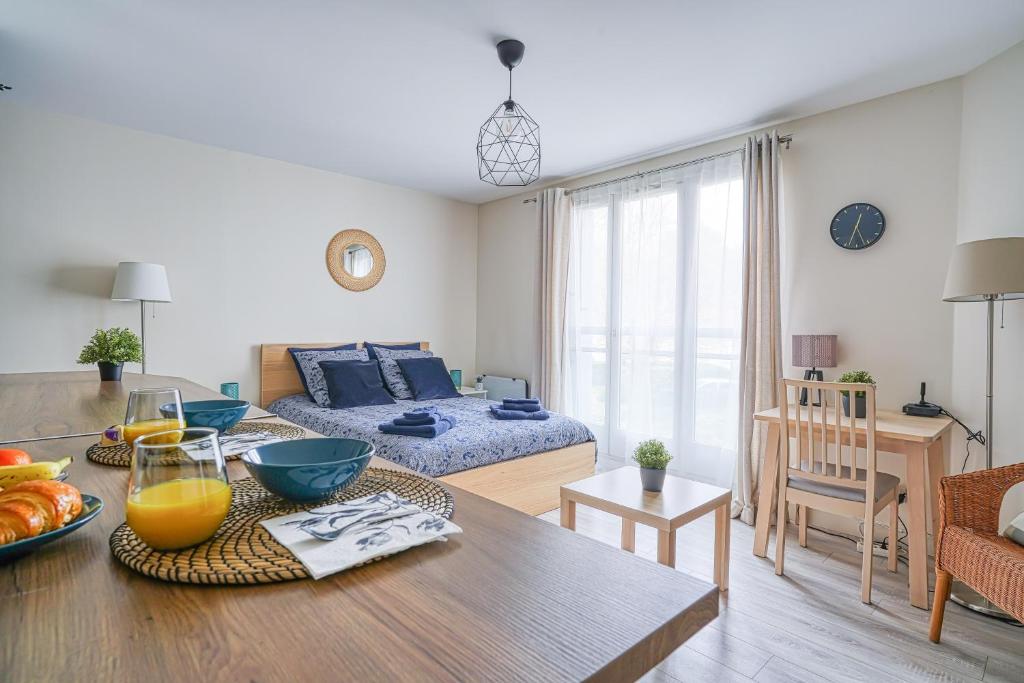 Logement Noah في Courcouronnes: غرفة معيشة مع أريكة وطاولة