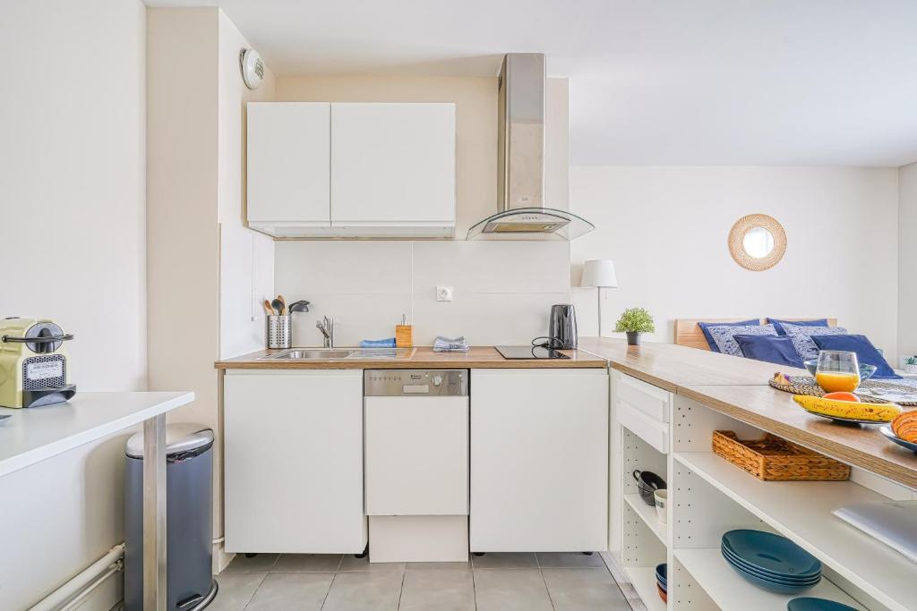 a kitchen with white cabinets and a sink at Logement Noah in Courcouronnes