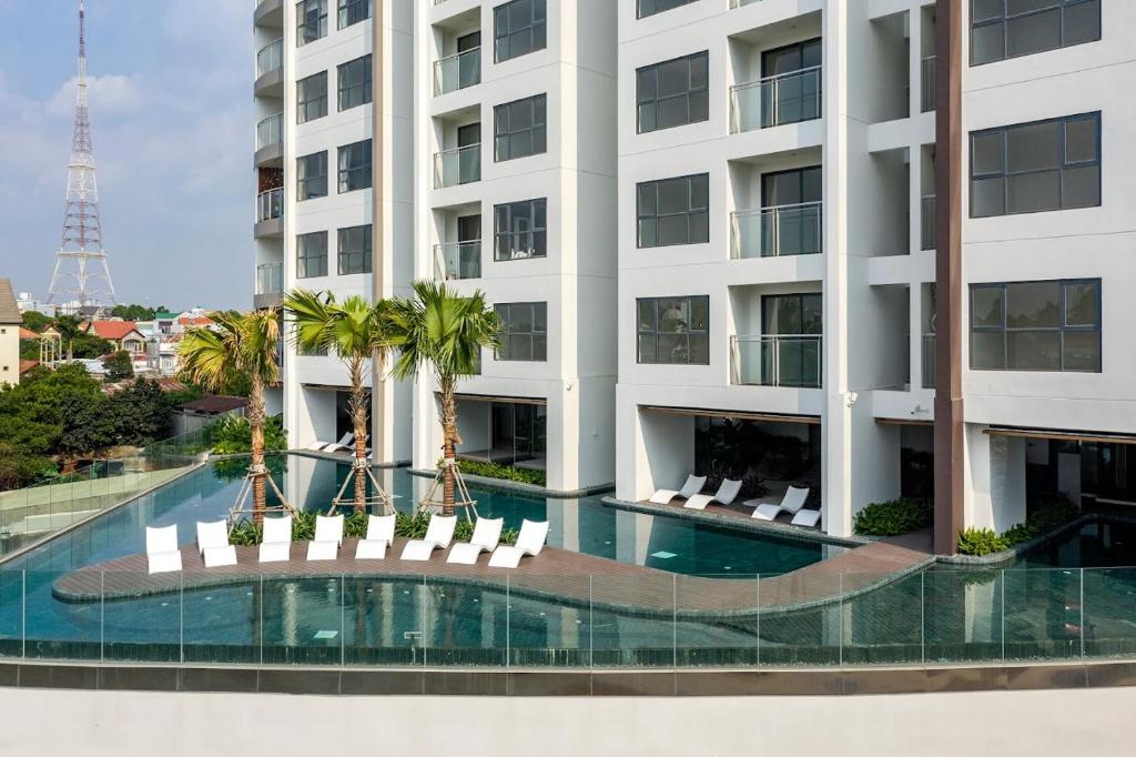 un immeuble d'appartements avec piscine et palmiers dans l'établissement Hoa's lovely 2-bedroom condo with pool, à Ấp Phú Thọ