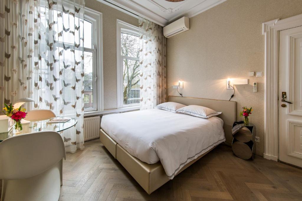 Postel nebo postele na pokoji v ubytování Amstel Corner Hotel