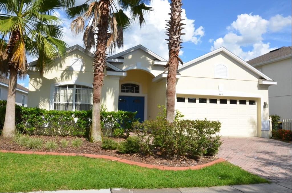 a white house with palm trees in front of it at 4 Bed 3 Bath 448 Birkdale, overlooks golf course, home in Davenport