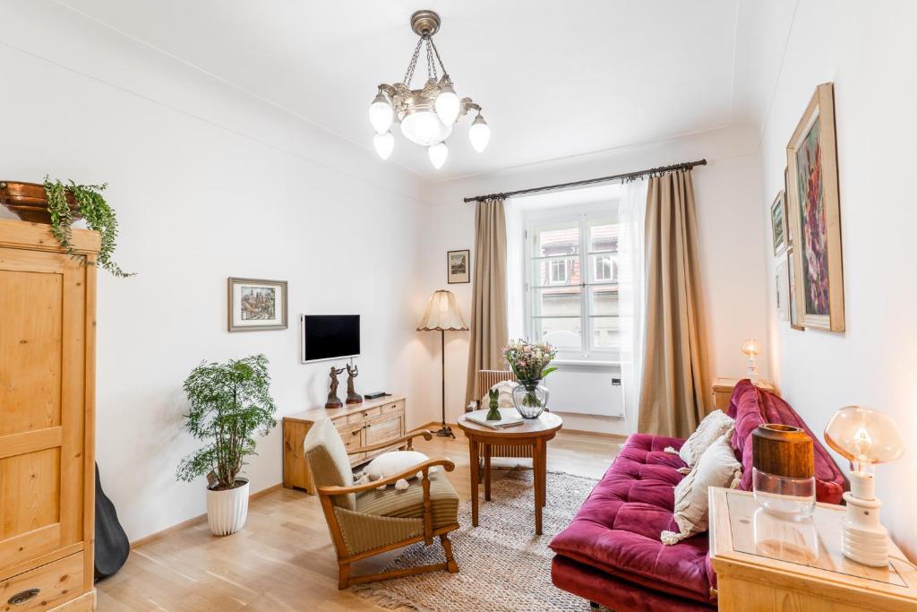 un soggiorno con divano rosso e tavolo di Charming Apartment in Lesser Town a Praga