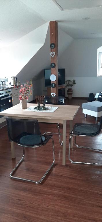 einen Tisch und zwei Stühle im Wohnzimmer in der Unterkunft Pension-Nussbaum in Grünewalde