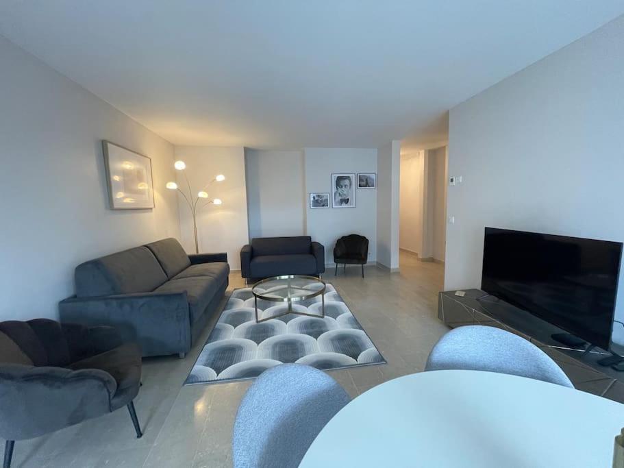 sala de estar con sofás y TV de pantalla plana. en Le Mont-Veyrier, parking et vue, en Annecy