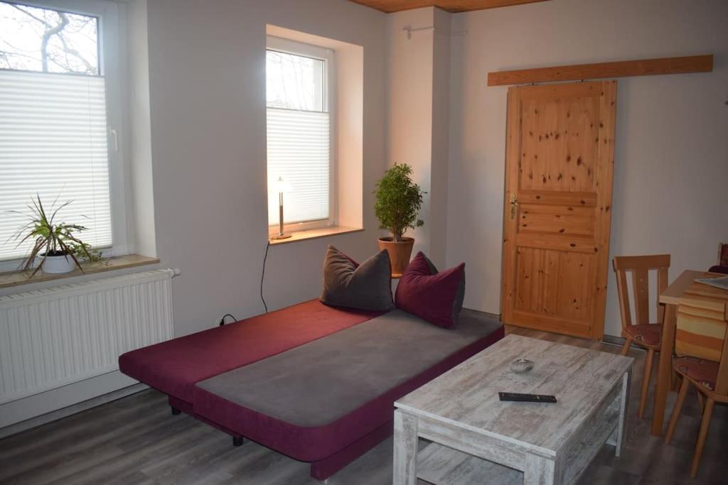 1 dormitorio con cama, mesa y ventanas en City Appartement mit Garten, zentral und trotzdem ruhig, en Cottbus