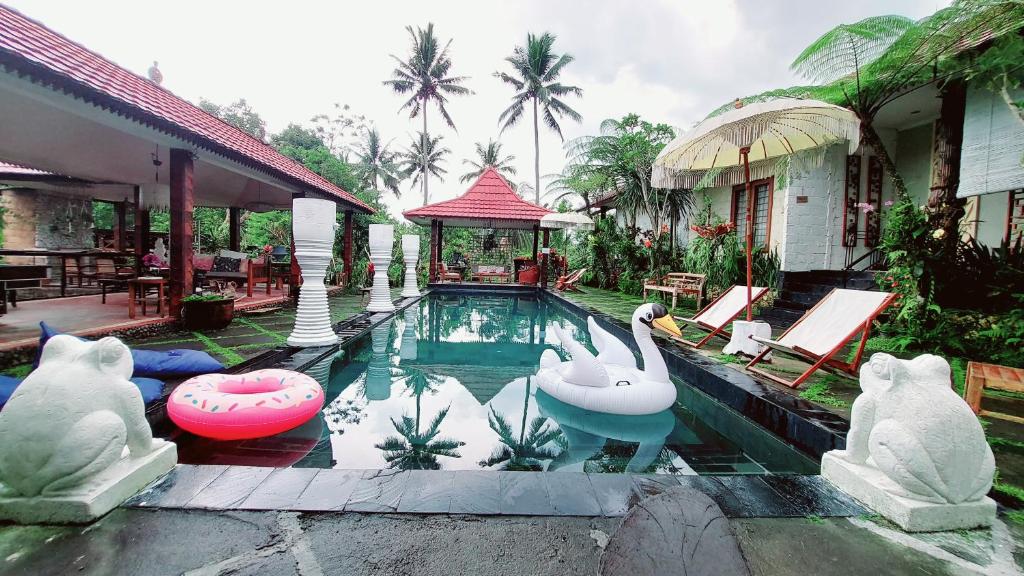 a swimming pool with swans in the middle of a house at Villa Padi Cangkringan in Yogyakarta