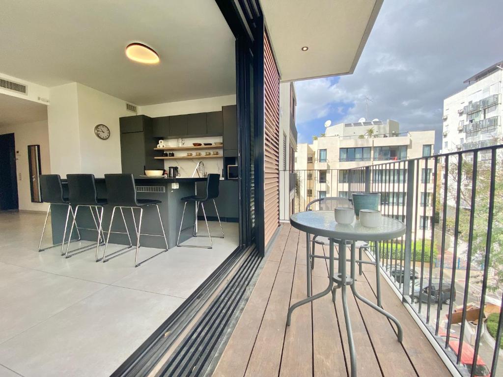 balkon ze stołem i krzesłami w obiekcie 8 Hulda - By Beach Apartments TLV w Tel Awiwie
