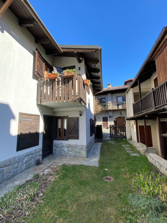a building with a balcony and a yard at Les Arnauds in Bardonecchia
