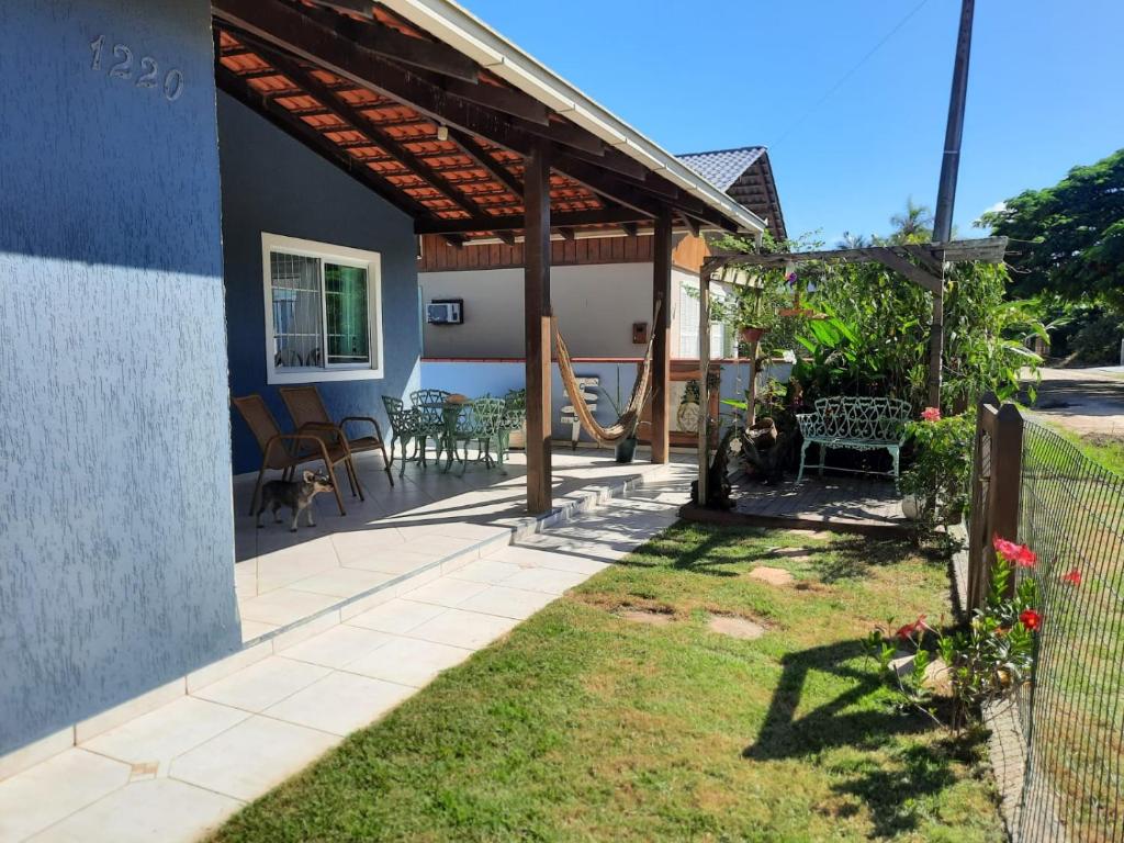 a house with a patio with chairs and tables at casa no paraíso do Capri in São Francisco do Sul