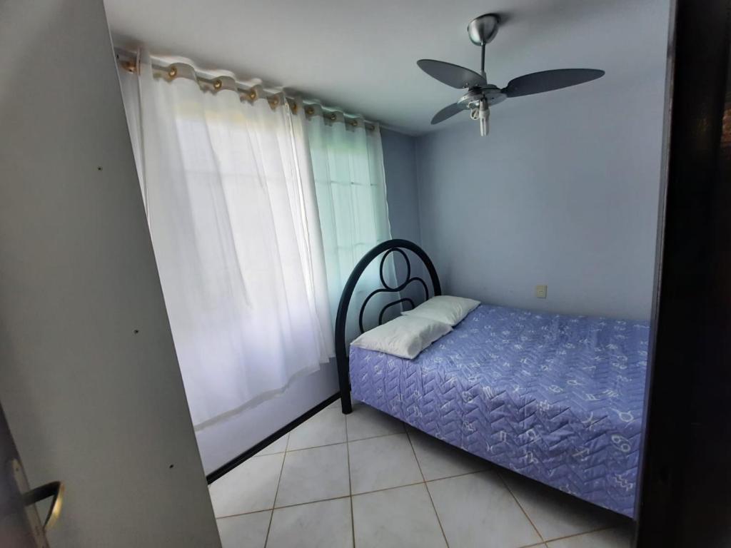 a bedroom with a bed and a ceiling fan at casa no paraíso do Capri in São Francisco do Sul