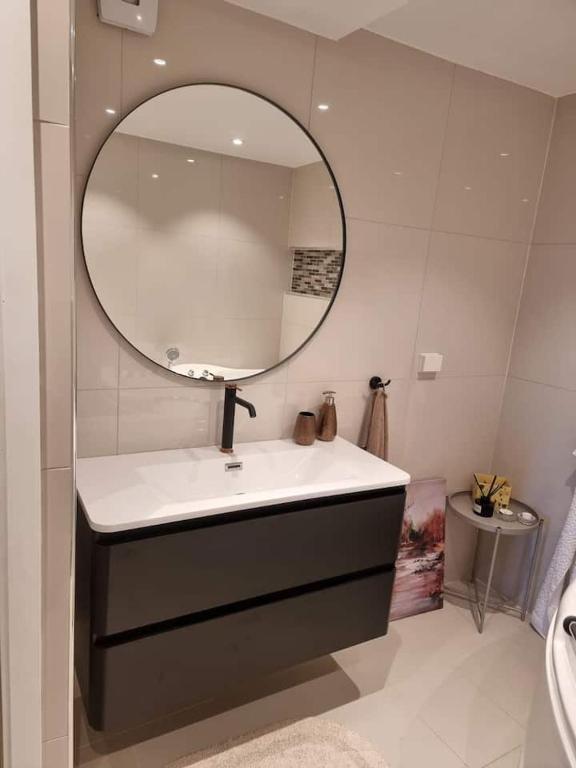 ein Bad mit einem Waschbecken und einem Spiegel in der Unterkunft Cosy room with luxurious bathroom in Flateby