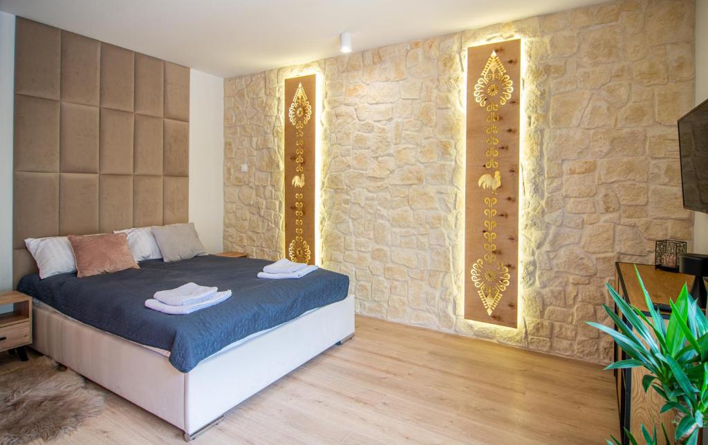 sypialnia z łóżkiem i kamienną ścianą w obiekcie Góry i Doliny w Kazimierzu Dolnym
