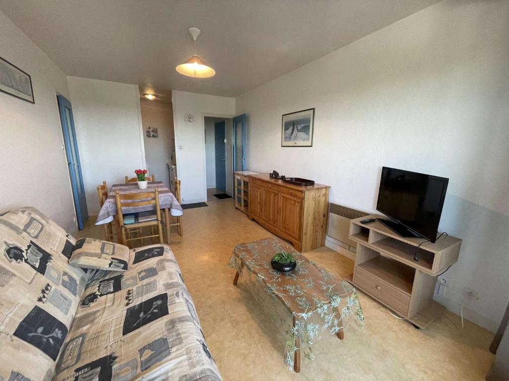 un salon avec un canapé et une télévision à écran plat dans l'établissement Appartement cosy proche plage avec balcon et vue mer - FR-1-224C-48, à Saint-Hilaire-de-Riez