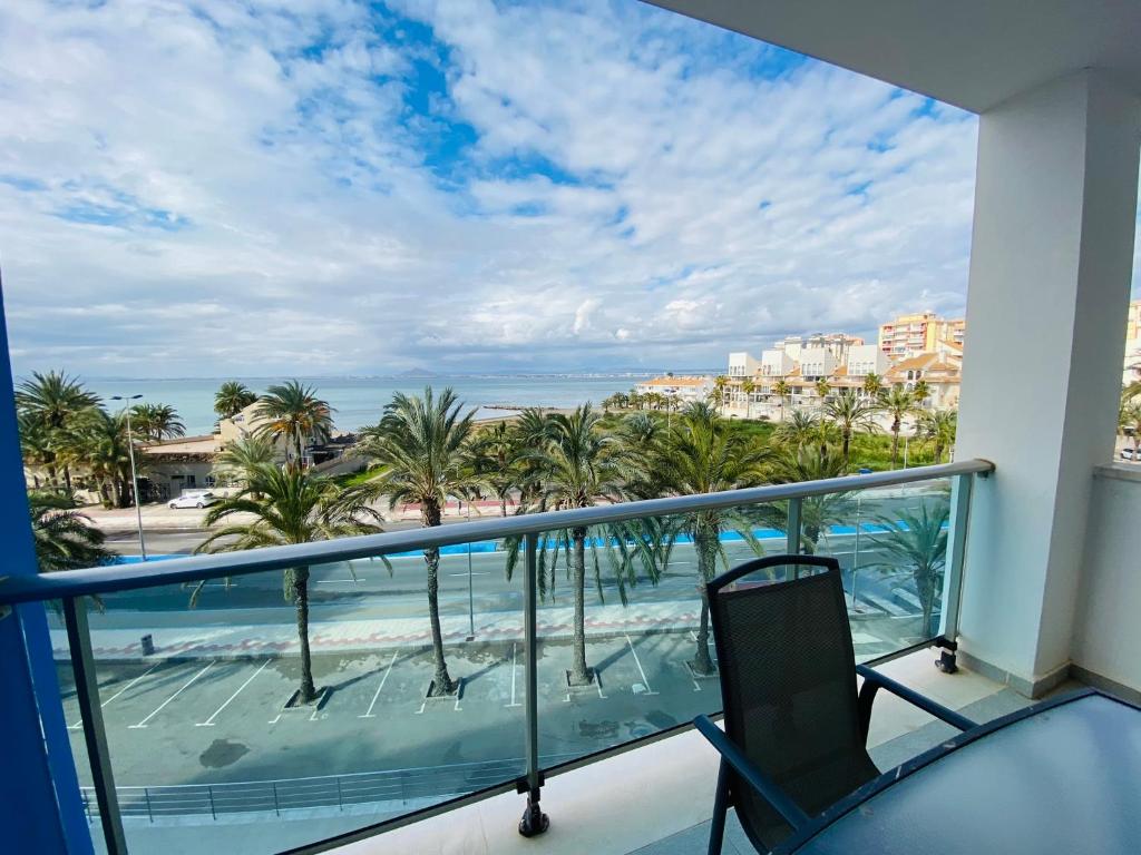 a balcony with a view of the beach and palm trees at Mar Azul in La Manga del Mar Menor