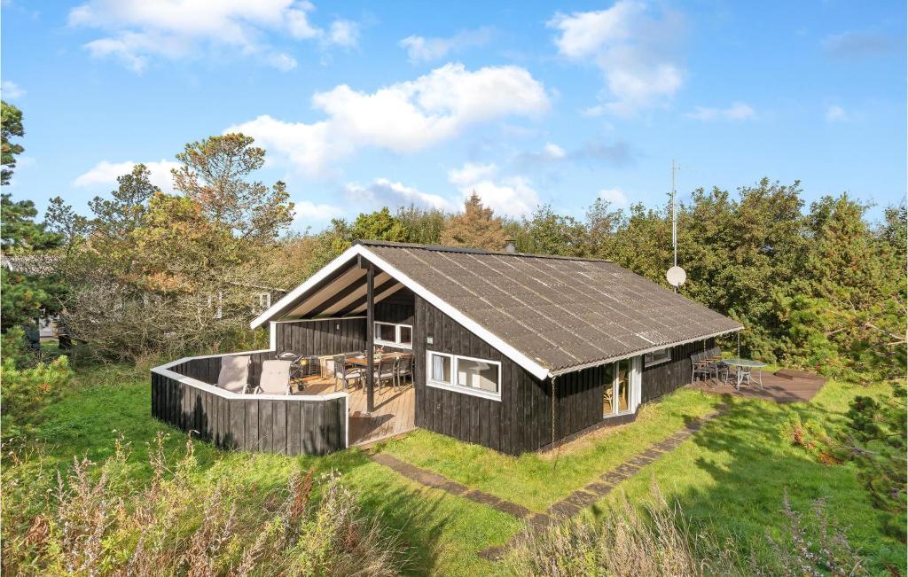 a black house on top of a grassy field at Holiday Home Grærup Havvej Oksbøl Iv in Vejers Strand