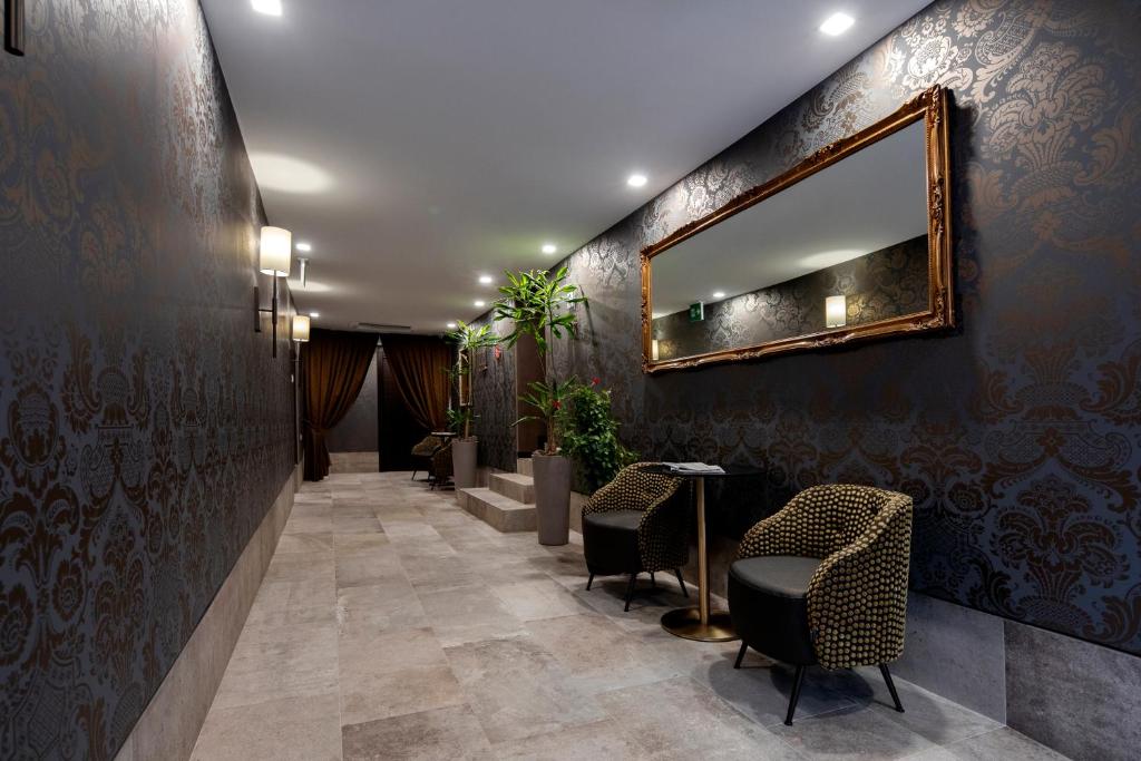 a hallway with a mirror and chairs in a lobby at Alle Guglie Boutique Hotel in Venice