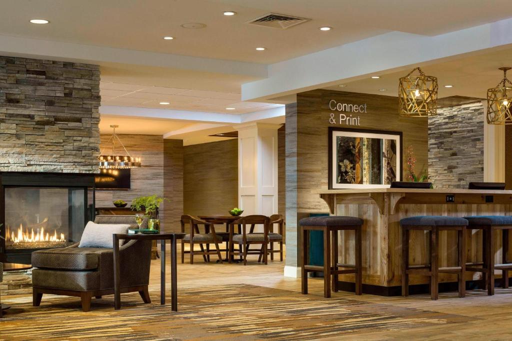 a bar in a hotel lobby with a fireplace at Fairfield by Marriott Waterbury Stowe in Waterbury