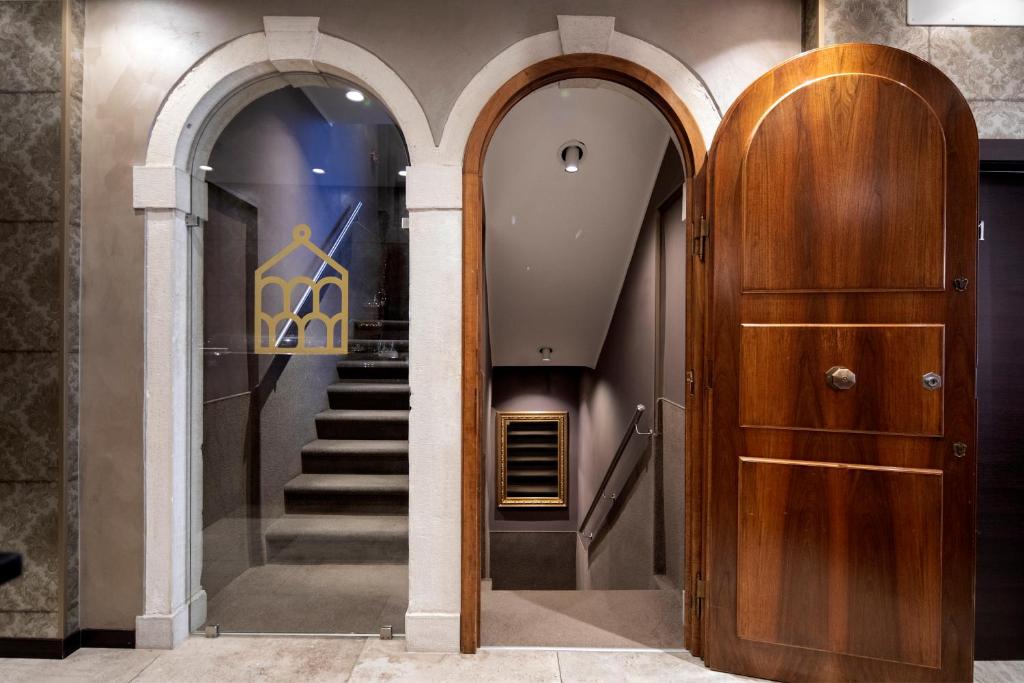 a hallway with two arches and a wooden door at Alle Guglie Boutique Hotel in Venice