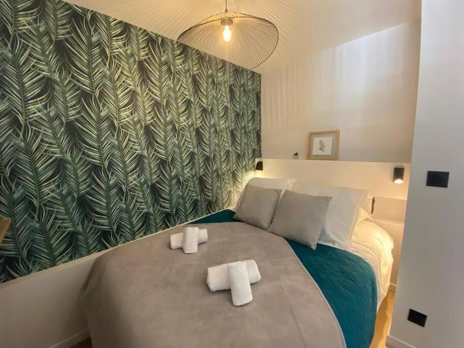 une chambre avec un lit avec deux serviettes dessus dans l'établissement Quai des Cordeliers, balcon et vieille ville, à Annecy