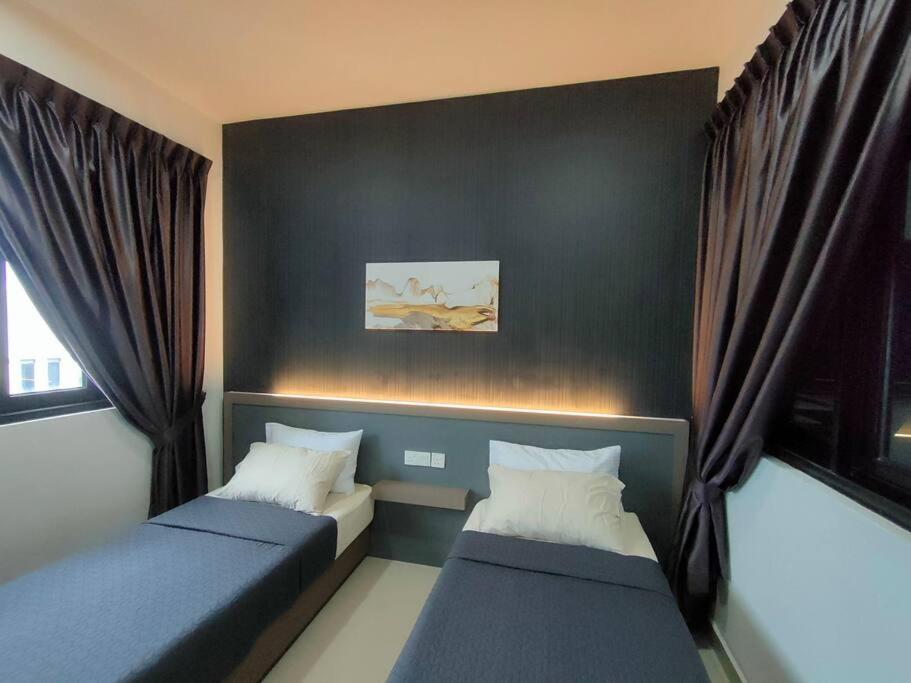 two beds in a room with black walls and curtains at Meridin Medini Sovo, Iskandar Puteri, Johor in Nusajaya