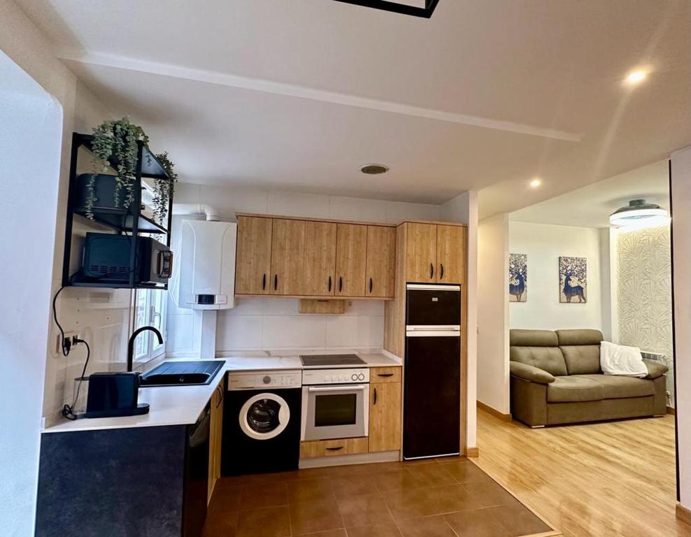 a kitchen with a stove top oven next to a couch at LA ISLA DE PEREZ GALDOS in Logroño