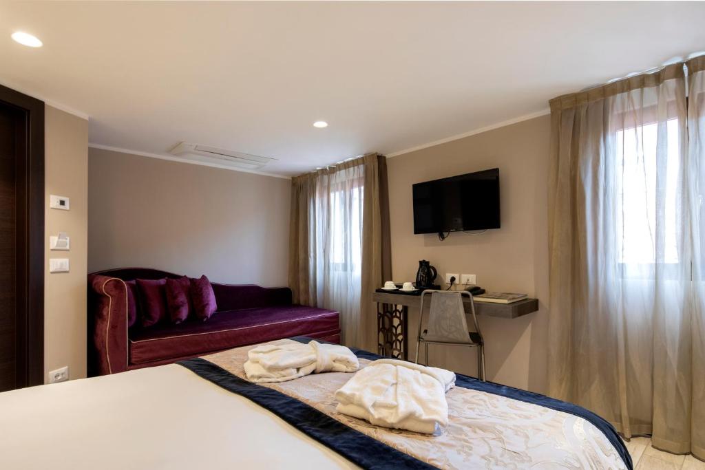 a hotel room with a bed and a couch at Alle Guglie Boutique Hotel in Venice