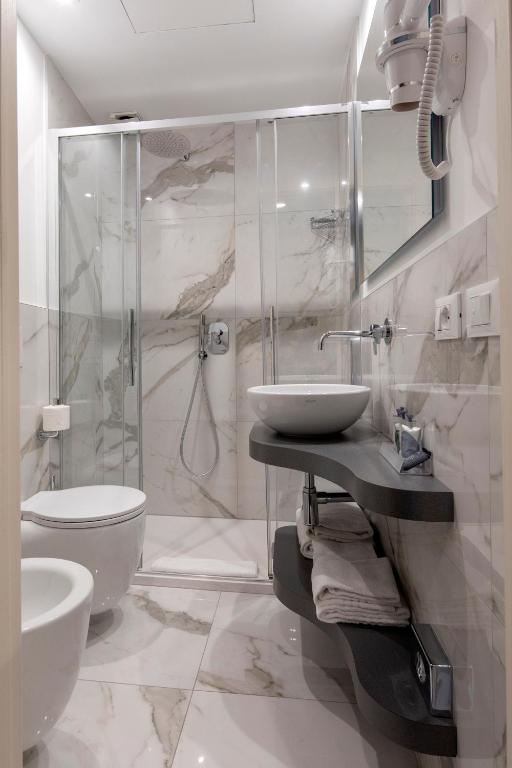 a white bathroom with a sink and a toilet at Alle Guglie Boutique Hotel in Venice