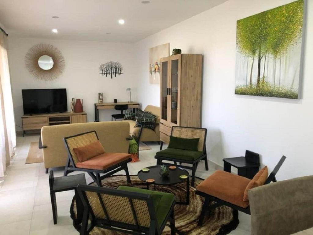 sala de estar con sillas, sofá y TV en L'UMBRIA, en Calvi