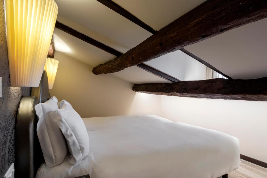 a bedroom with a white bed and two lights at Alle Guglie Boutique Hotel in Venice