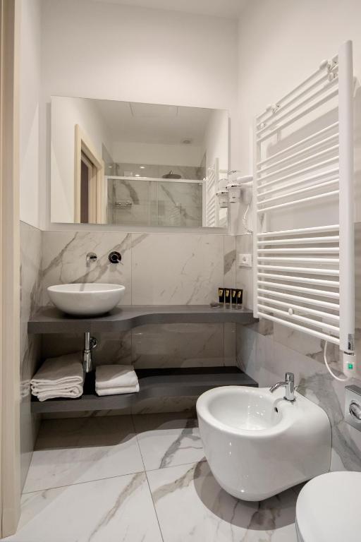 un bagno bianco con lavandino e WC di Alle Guglie Boutique Hotel a Venezia