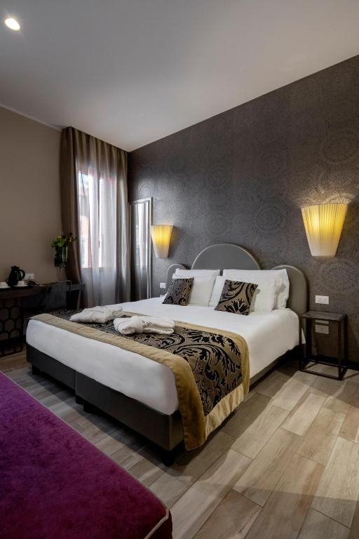 a bedroom with a large bed and a purple rug at Alle Guglie Boutique Hotel in Venice