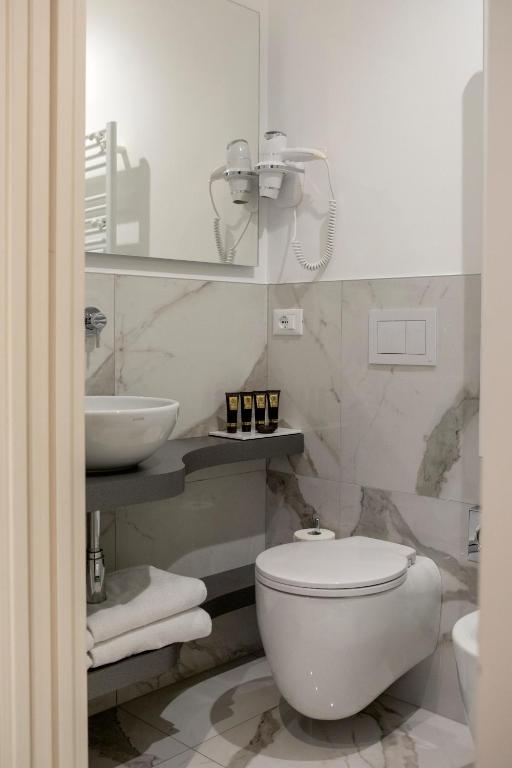 a white bathroom with a toilet and a sink at Alle Guglie Boutique Hotel in Venice