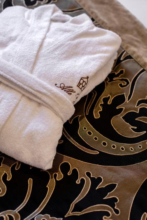 a pile of towels sitting on top of a bed at Alle Guglie Boutique Hotel in Venice