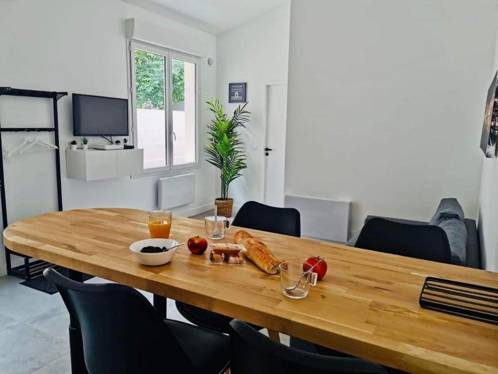 einen Holztisch mit Essen darauf im Wohnzimmer in der Unterkunft Le Repère de B&C in Cenon