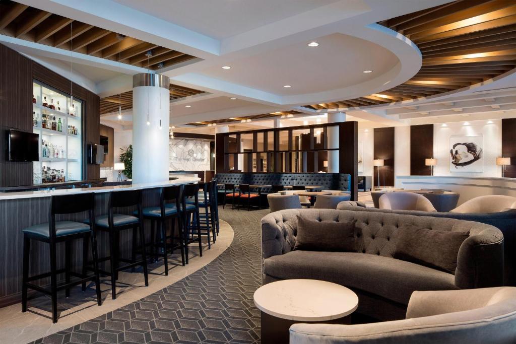 a bar in a hotel lobby with couches and chairs at Sheraton Cavalier Calgary Hotel in Calgary