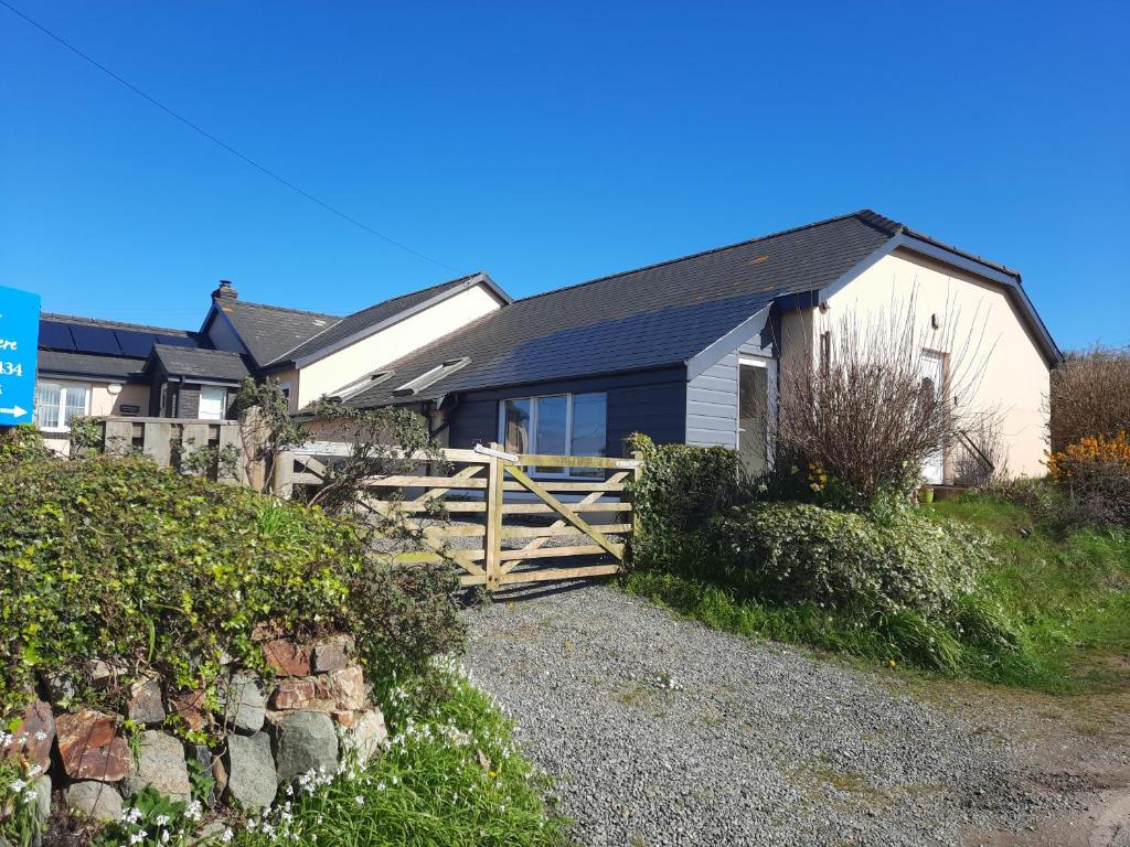 une maison avec une porte en bois et une clôture dans l'établissement Cwmwdig Cwtch (3 minutes drive to Abereiddy bay!), à Haverfordwest