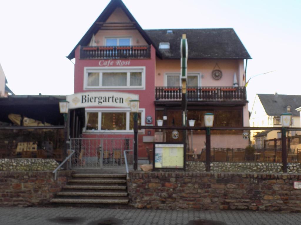 - un bâtiment rose avec des escaliers devant dans l'établissement Cafe Rosi, à Bernkastel-Kues