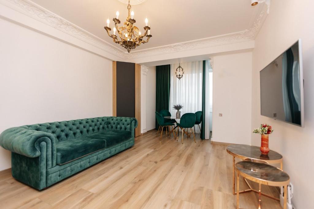 a living room with a green couch and a table at Main Street Sky House Apartments in Chişinău