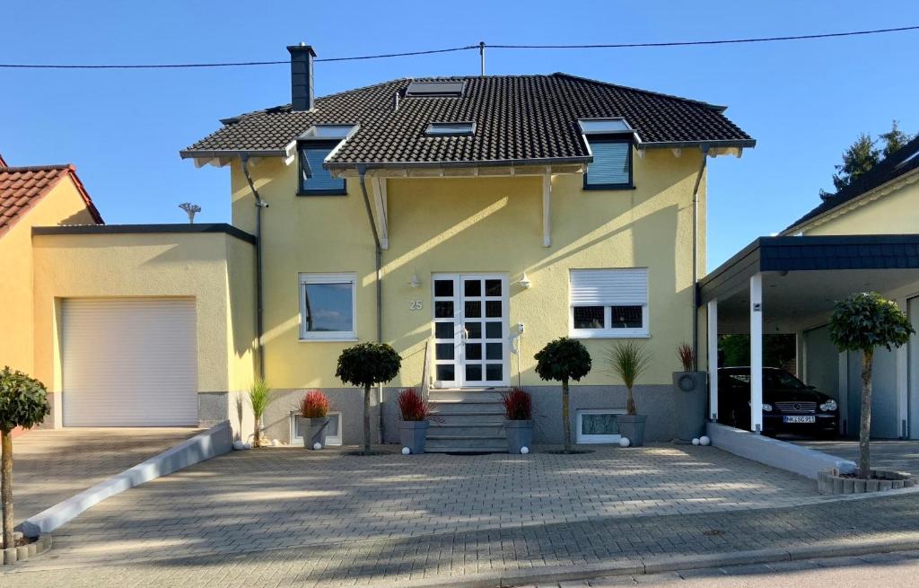 une maison jaune avec un toit noir dans l'établissement Gästehaus Backes, à Eppelborn