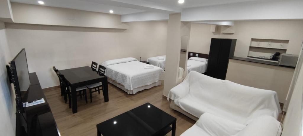 a room with two beds and a table and a room with a bed at Montequinto apartamento 50m en Semisótano in Dos Hermanas