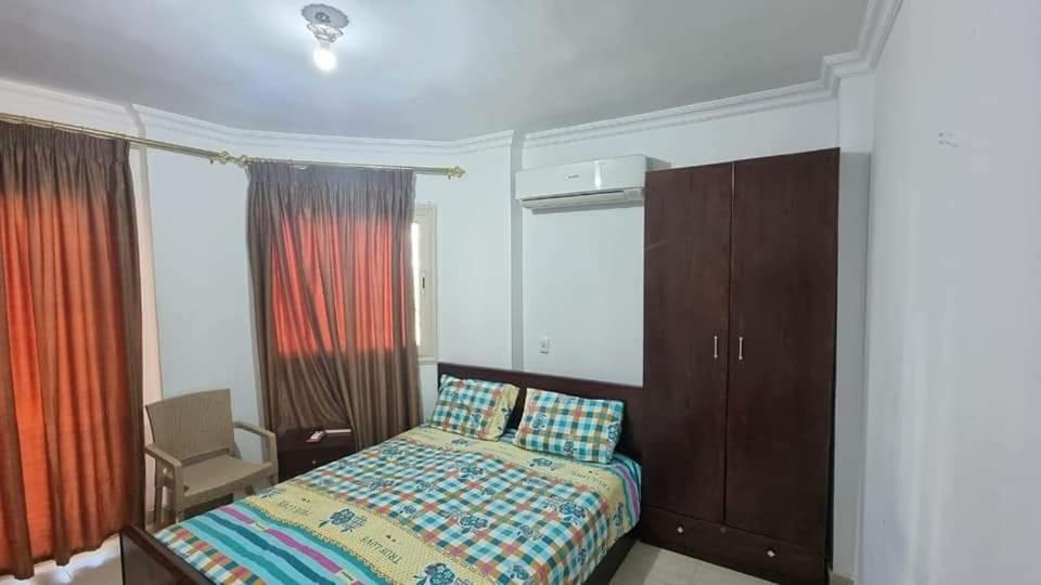 a bedroom with a bed and a chair and windows at شيماء كسل in Cairo