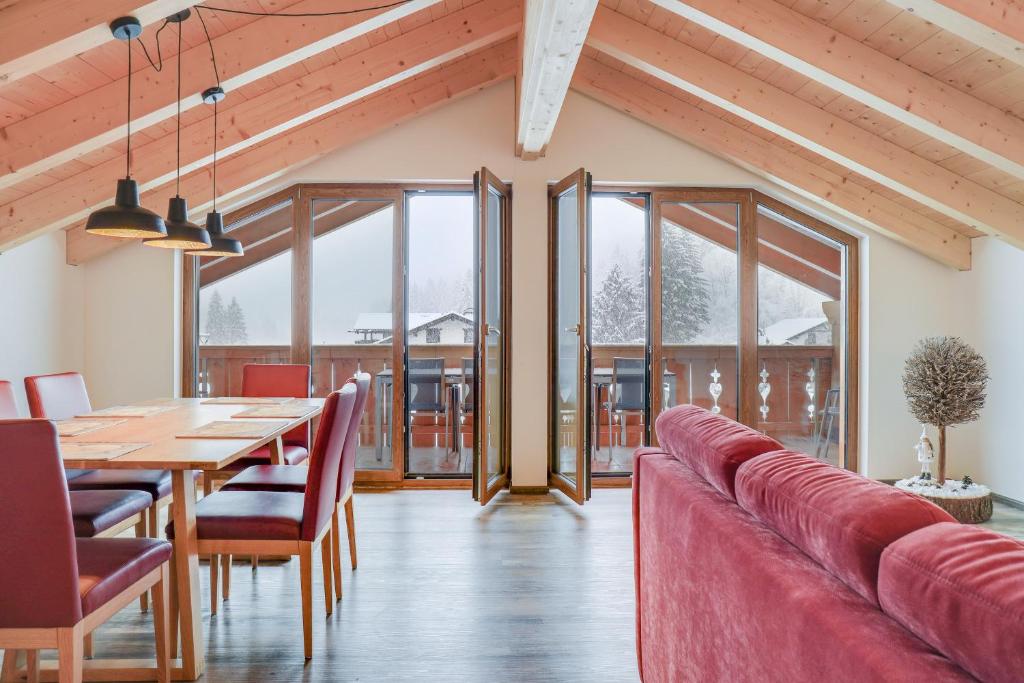 - une salle à manger avec une table et un canapé rouge dans l'établissement Ferienwohnung Partnachklamm, à Garmisch-Partenkirchen