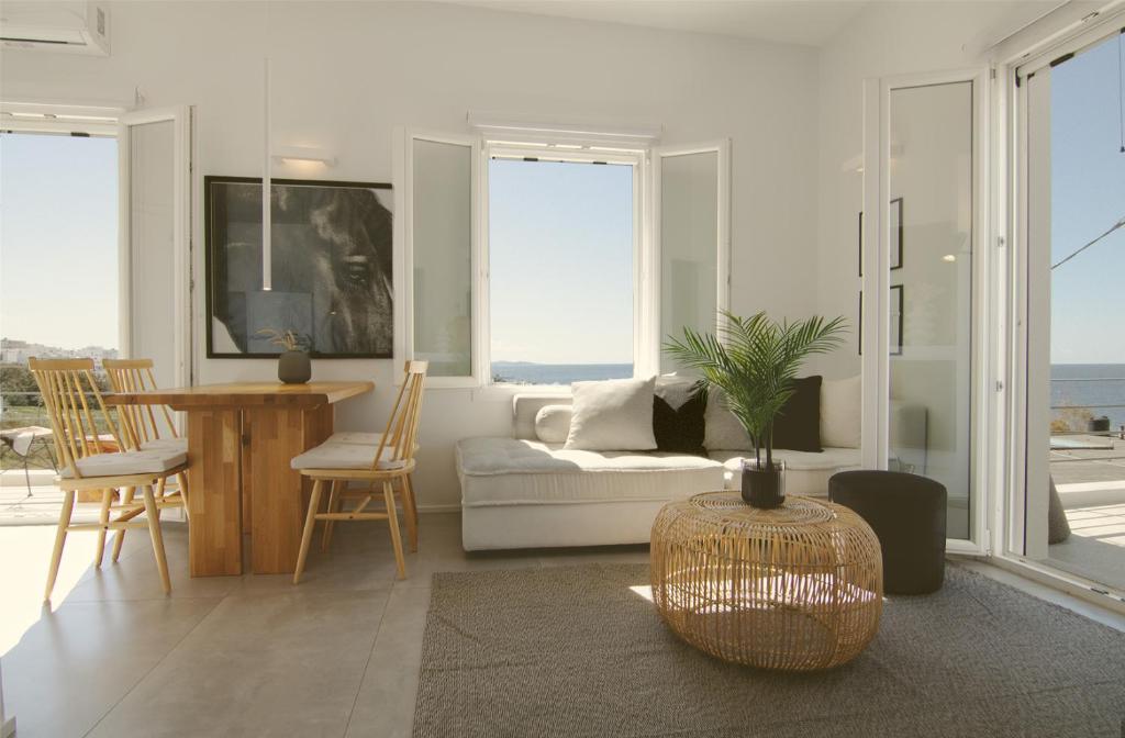 een woonkamer met een bank en een tafel en stoelen bij AELIA Tinos in Tinos Town