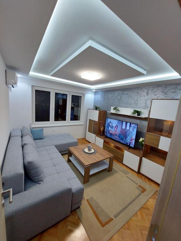 a living room with a couch and a tv at Matej LUX Apartment in Skopje