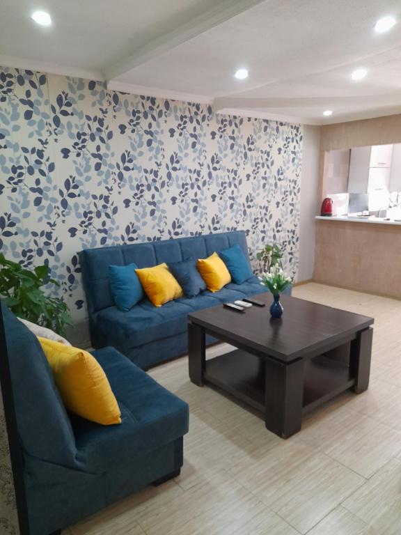 uma sala de estar com um sofá azul e uma mesa de centro em Bella Apartment em Tbilisi