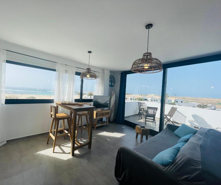a living room with a blue couch and a table at Casa Iris El Cotillo in Cotillo